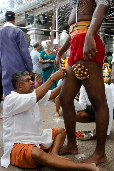 Gancho devoto con campanas perforadas en las piernas —  Fotos de Stock