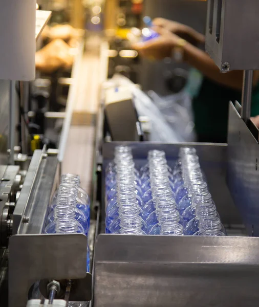 Production line collecting empty plastic bottle from blowing machine before packing in plastic bag