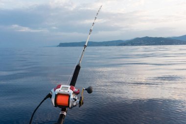 Elektrik balıkçılık reel bir çubuk adam denizde ile monte