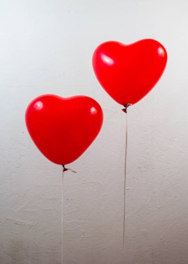 Beyaz zemin üzerine kırmızı kalp balonlar