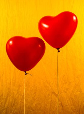 Sarı zemin üzerine kırmızı kalp balonlar