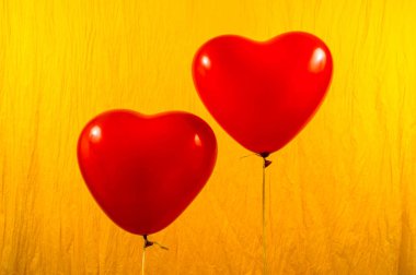 Sarı zemin üzerine kırmızı kalp balonlar