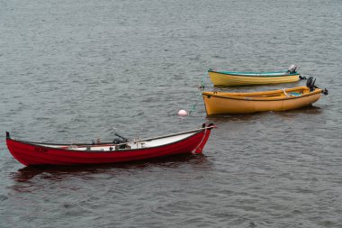 bir kırmızı tekne ve Faroe Adaları bir gölde iki sarı tekne