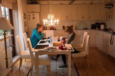 Anne kızıyla birlikte yemek yemekte mutfakta