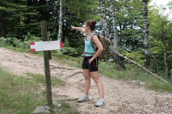 girl shows the right direction during a mountain hike