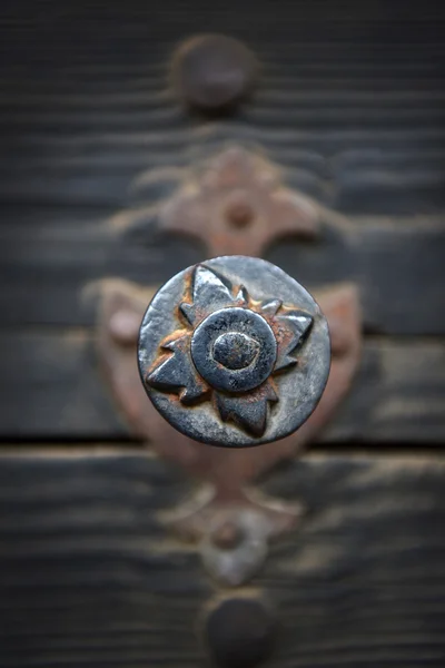 Ржавая металлическая дверная ручка на старинной деревянной двери — стоковое фото