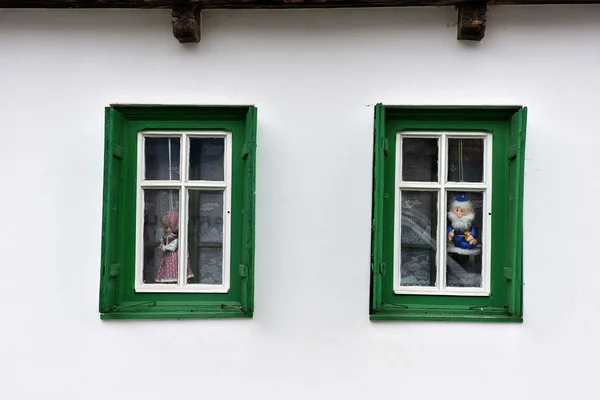 Bonecas na janela em uma casa de aldeia — Fotografia de Stock