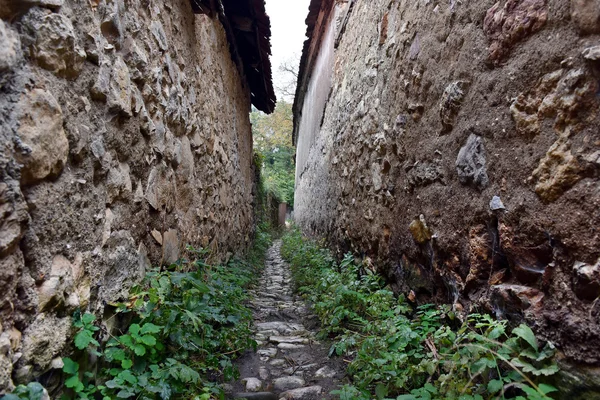 Enge Dorfgasse mit Steinmauern — Stockfoto