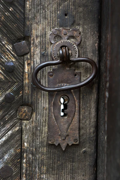 Ornamental vintage iron door handle on wooden door — Stock Photo, Image