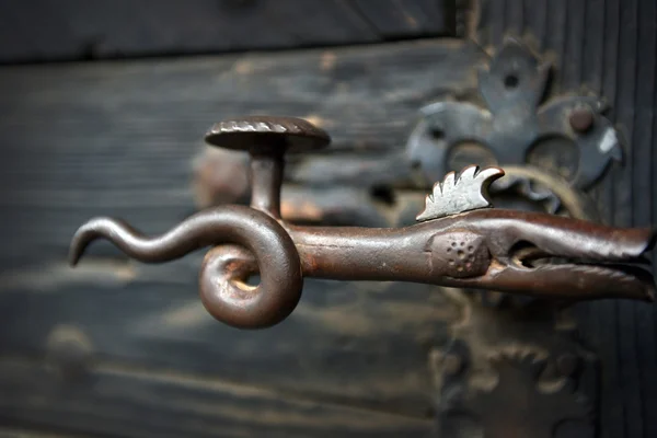 Ornamental vintage iron door handle on wooden door — Stock Photo, Image