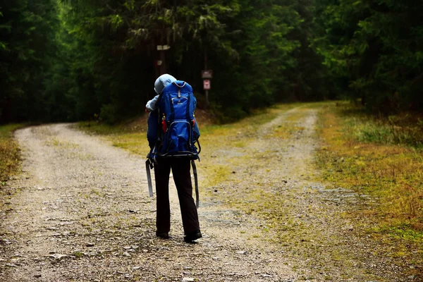 Młoda matka, trekking, niosąc jej dziecko w plecaku dziecka — Zdjęcie stockowe