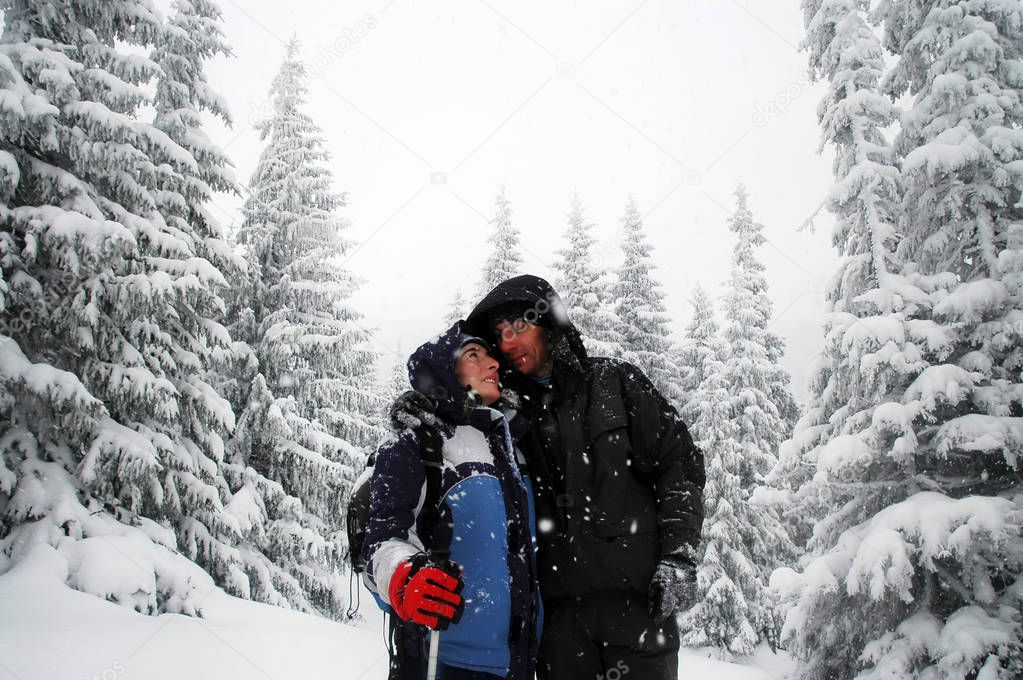 Romantic hiking couple embracing in the winter mountains