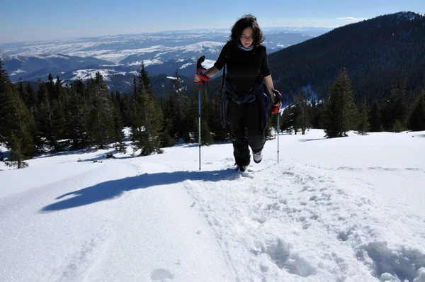 Mulher fazendo trekking inverno nas montanhas — Fotografia de Stock