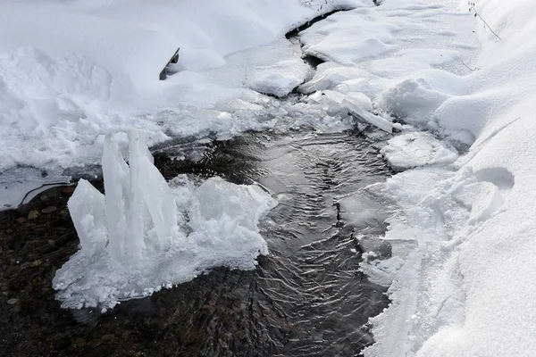 Donmuş buz kristalleri arasında küçük bir nehir — Stok fotoğraf