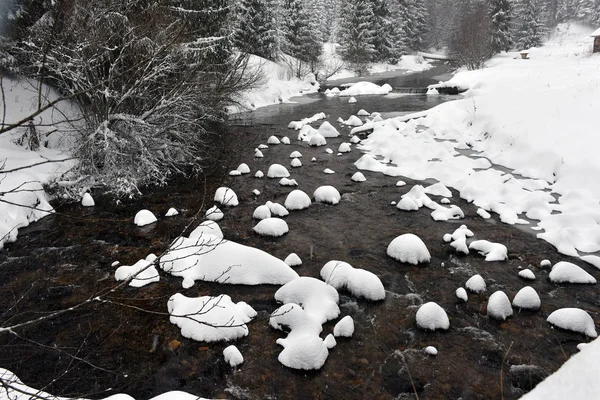 Riviertje met wit besneeuwde bomen en rotsen — Stockfoto