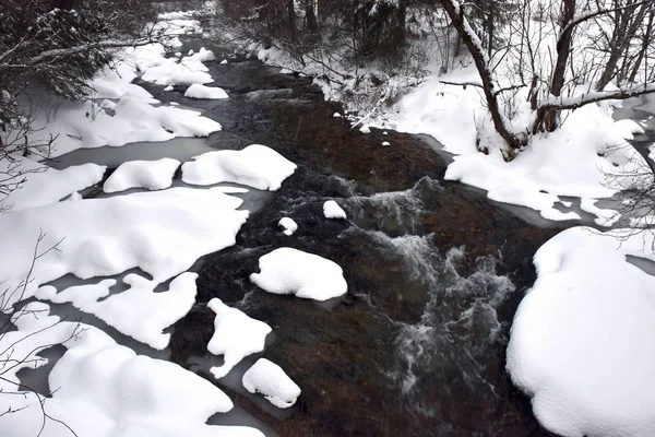 Malé zamrzlou řeku s čerstvým sněhem na skalách — Stock fotografie