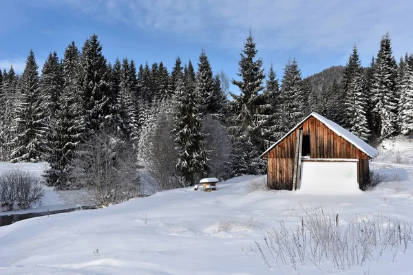 Paisaje invernal con una pequeña cabaña de madera — Foto de Stock