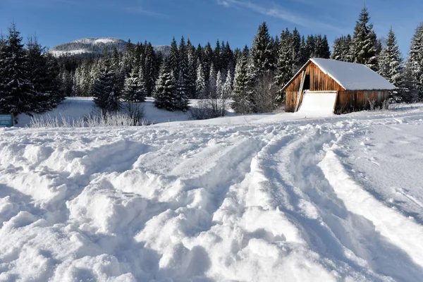 Paisaje invernal con una pequeña cabaña de madera — Foto de Stock