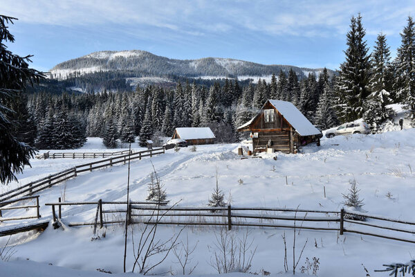 Winter landscape with a small wooden hut