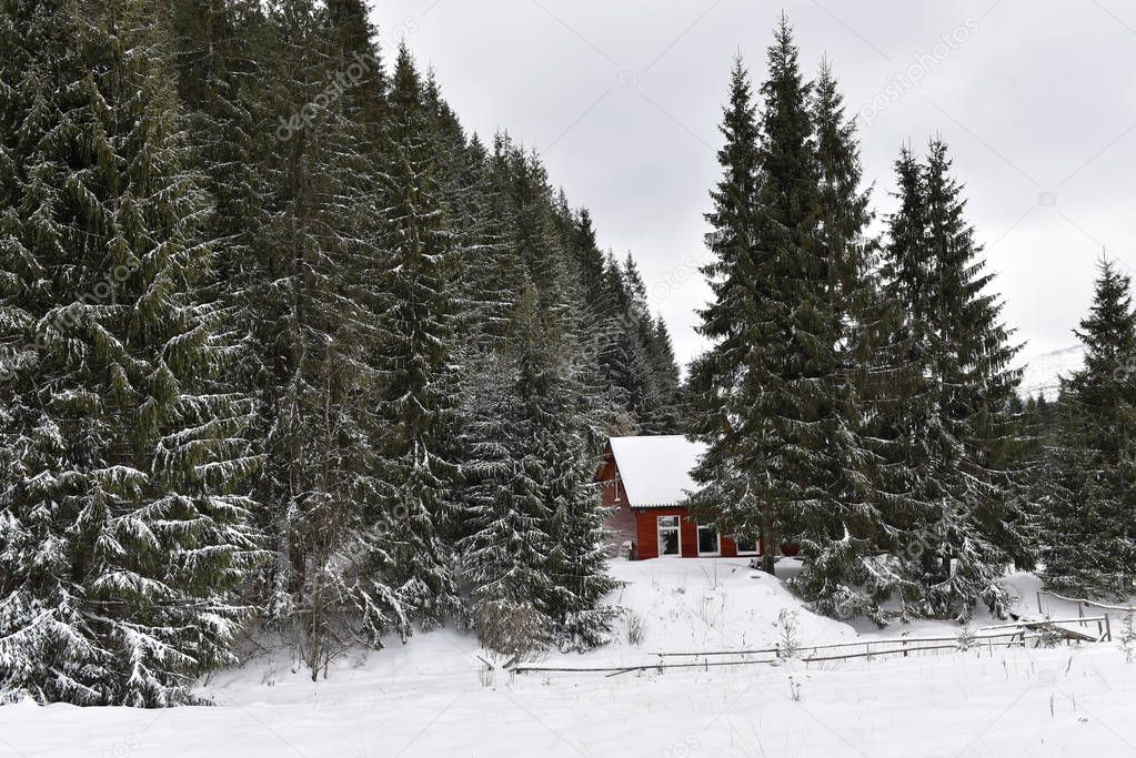 Winter landscape with a small wooden hut