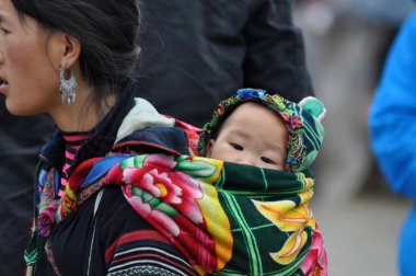 Vietnamca Hmong kadın çocuğunu taşıyan