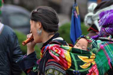 Vietnamca Hmong kadın çocuğunu taşıyan