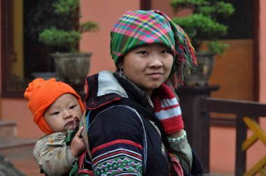 Vietnamca Hmong kadın çocuğunu taşıyan