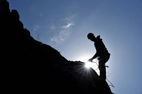 Σιλουέτα του ένα βράχο ορειβάτης που κρέμονται στον τοίχο — Φωτογραφία Αρχείου