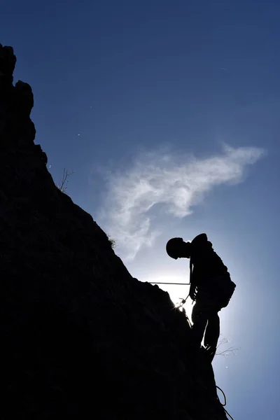 벽에 걸려 바위 산악인의 실루엣 — 스톡 사진