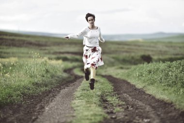 Bir kırsal yolda kaçan neşeli kız