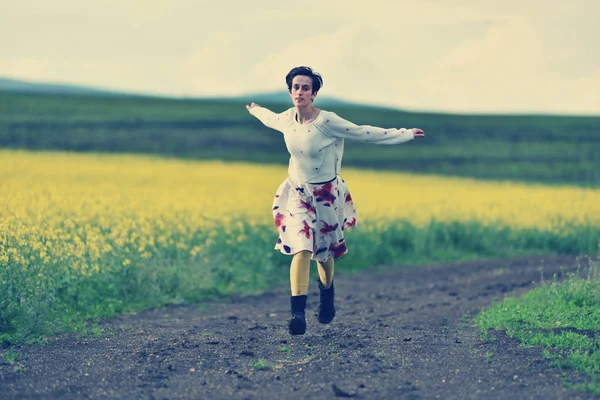 Mujer joven corriendo en un camino rural — Foto de Stock