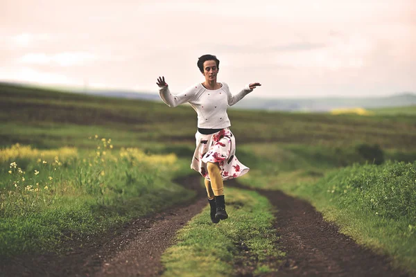 Schöne Frau läuft auf einer Landstraße — Stockfoto