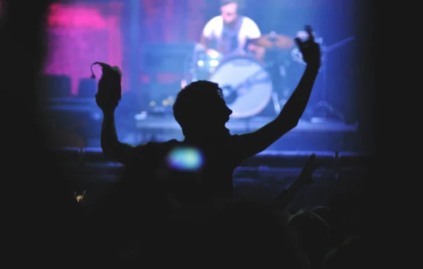 Rückansicht eines Mannes mit erhobenen Armen bei einem Konzert — Stockfoto