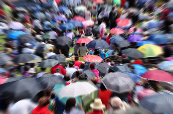 Verwackelte defokussierte Menschenmenge mit Regenschirmen — Stockfoto