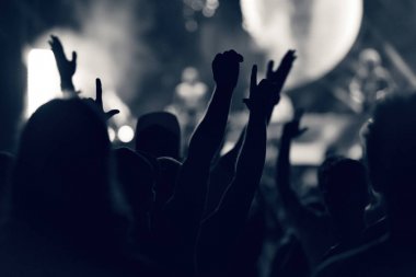 Kalabalık seyirci kadar eller yükselterek bir müzik konserinde tonda