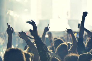 Yükseltilmiş silah ile bir konser sırasında sallanan kalabalık.
