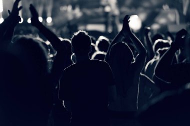 Kalabalık seyirci kadar eller yükselterek bir müzik konserinde tonda