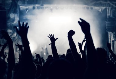 Kalabalık seyirci kadar eller yükselterek bir müzik konserinde tonda