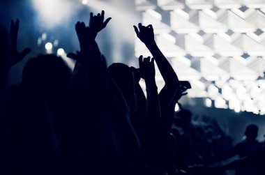 Kalabalık seyirci kadar eller yükselterek bir müzik konserinde tonda