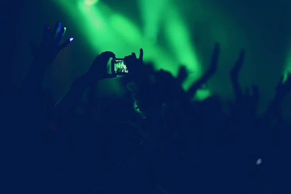 Publiken med armarna utsträckta på konsert — Stockfoto
