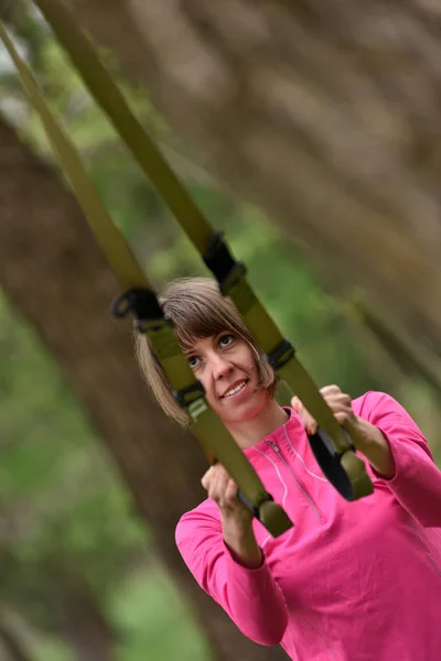 Woman doing arms biceps curl training with trx fitness straps — Stock Photo, Image