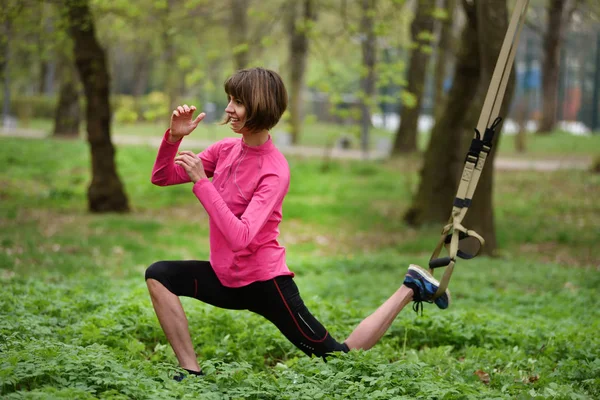 Vacker ung kvinna som gör Trx övning med suspension trainer — Stockfoto