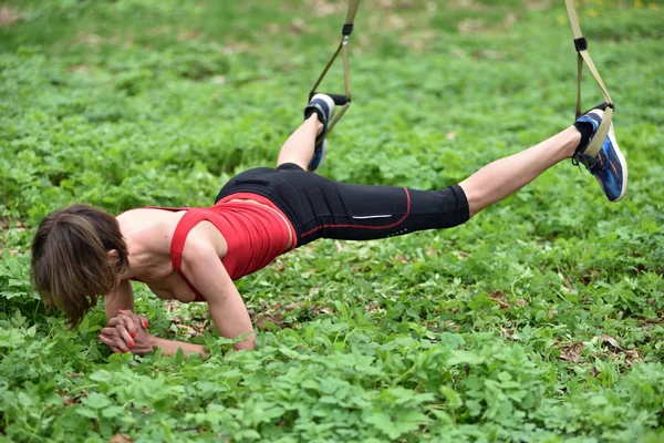 Vacker ung kvinna som gör Trx övning med suspension trainer — Stockfoto