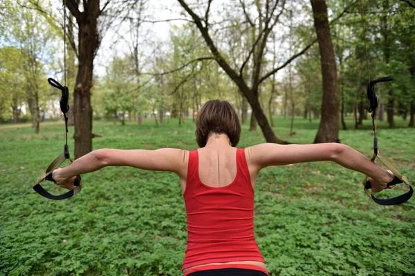 Młoda kobieta ma zawieszenie szkolenia fitness paski w — Zdjęcie stockowe