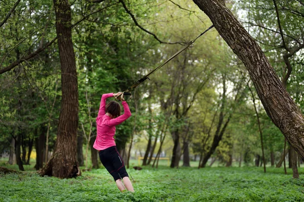 Ung attraktiv kvinna kroppen stretching med trx fitness str — Stockfoto