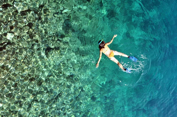 Mujer joven en traje de baño haciendo snorkel en un mar tropical poco profundo —  Fotos de Stock