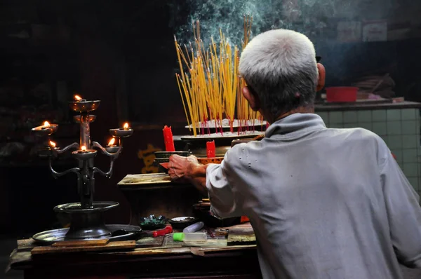 Asian people praying and burning incense sticks in a pagoda — Stock Photo, Image