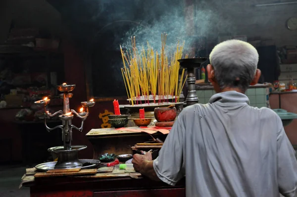 Asiatico persone pregare e bruciare incenso bastoni in una pagoda — Foto Stock