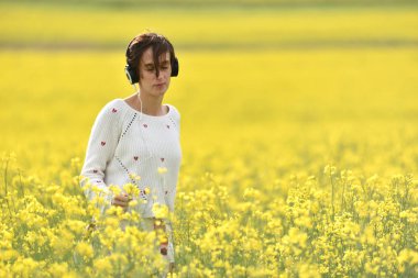 Beyaz kız açık havada kulaklık ile müzik dinlemek