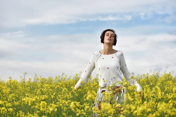 Hermosa chica caucásica escuchando música con auriculares en th — Foto de Stock